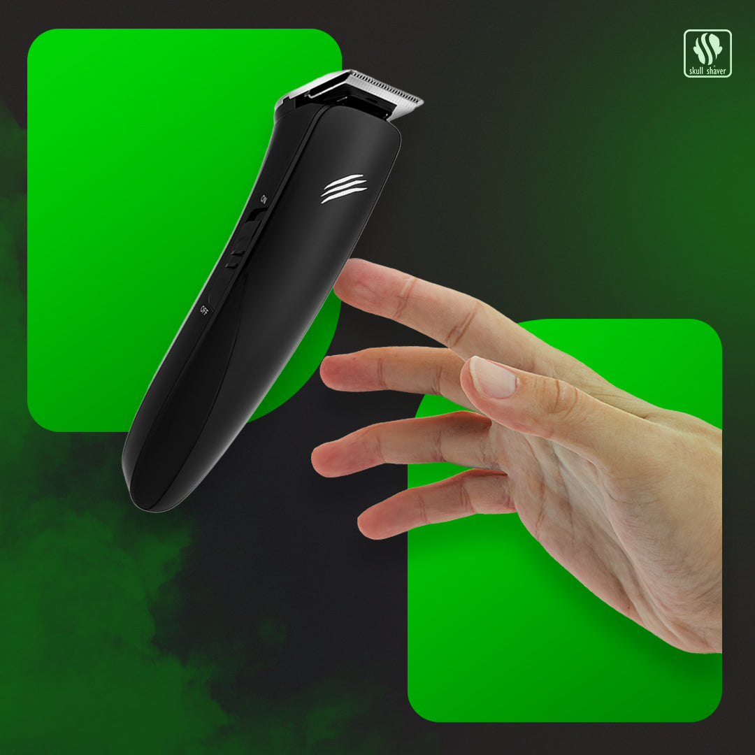 Black hair trimmer held by a hand against a green and black background