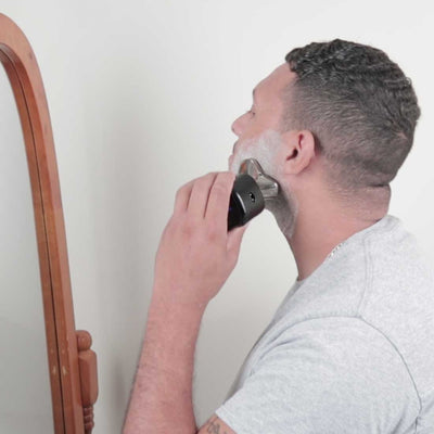 A guy with shaving foam on his face shaving with skull shaver. The Carver PRO 3 head blades can shave wet or dry